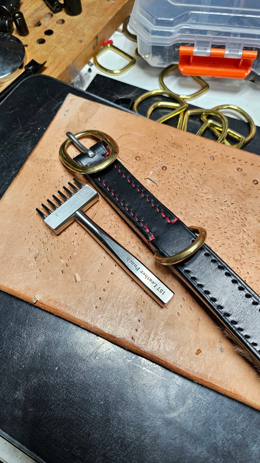 Leather belt with gold buckle on a workbench