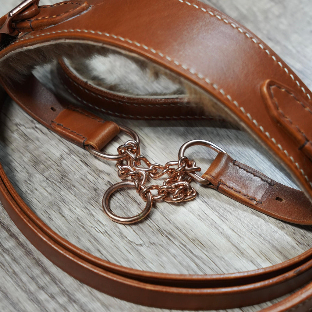 Brown leather strap with a keychain on a wooden surface