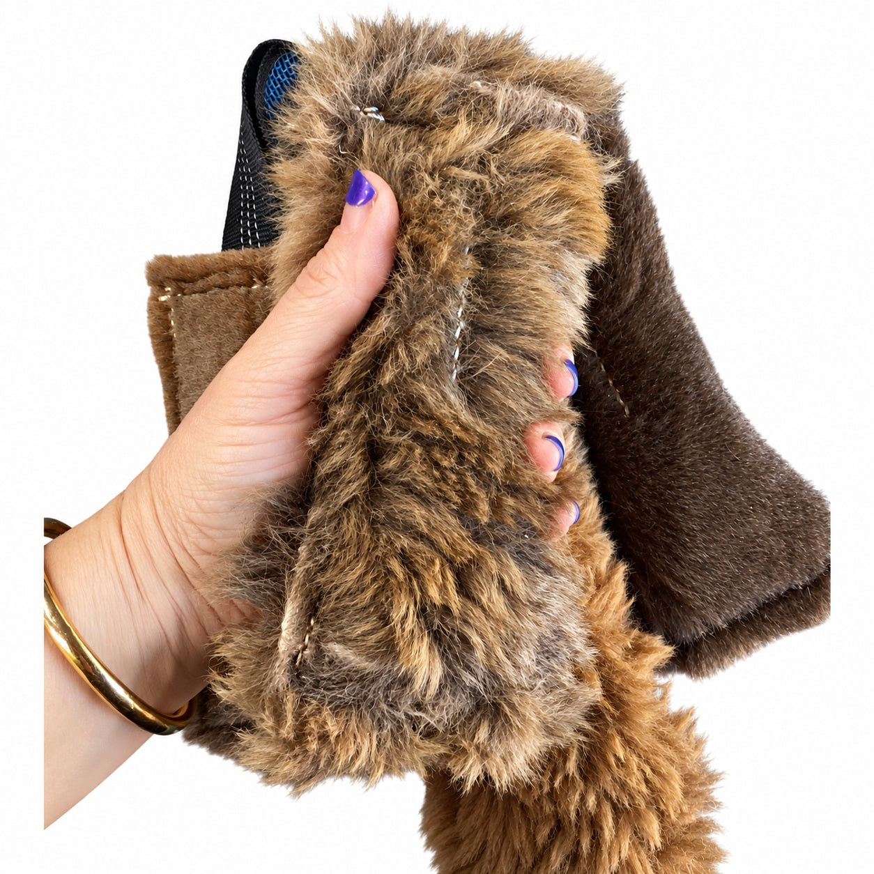 A hand holding a PK9 Gear small kangaroo tug toy, showing its fur texture and size with other tugs behind.