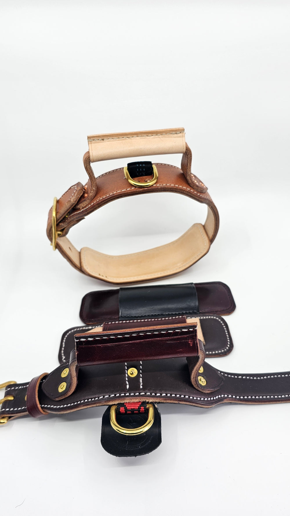 Tan collar with a pale handle beside a dark collar with a burgundy handle