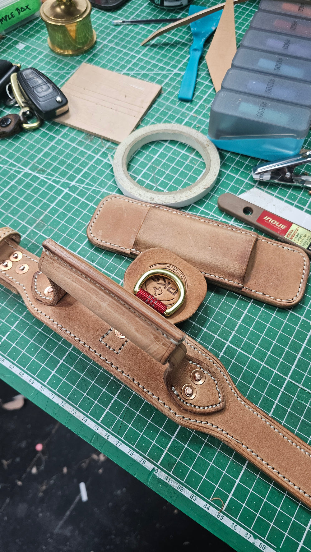 Natural tan leather collar and matching tan handle photographed on the workbench